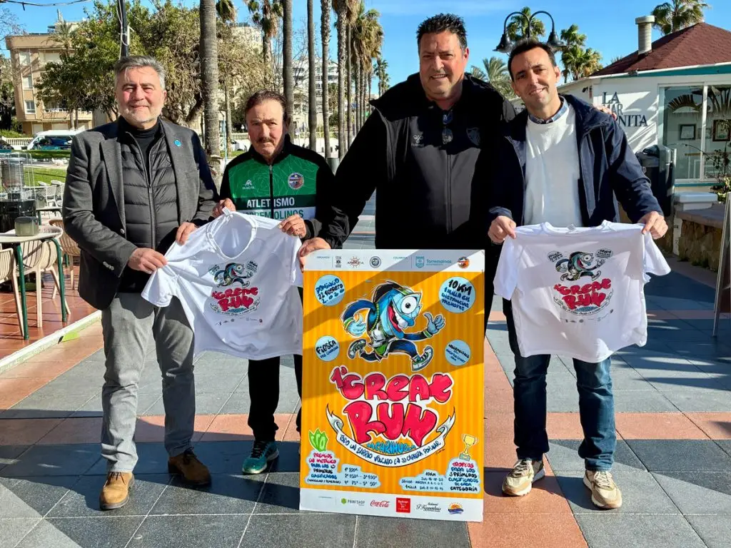 Presentación de la I Great Run La Carihuela en Torremolinos con organizadores mostrando la camiseta oficial y el cartel de la carrera