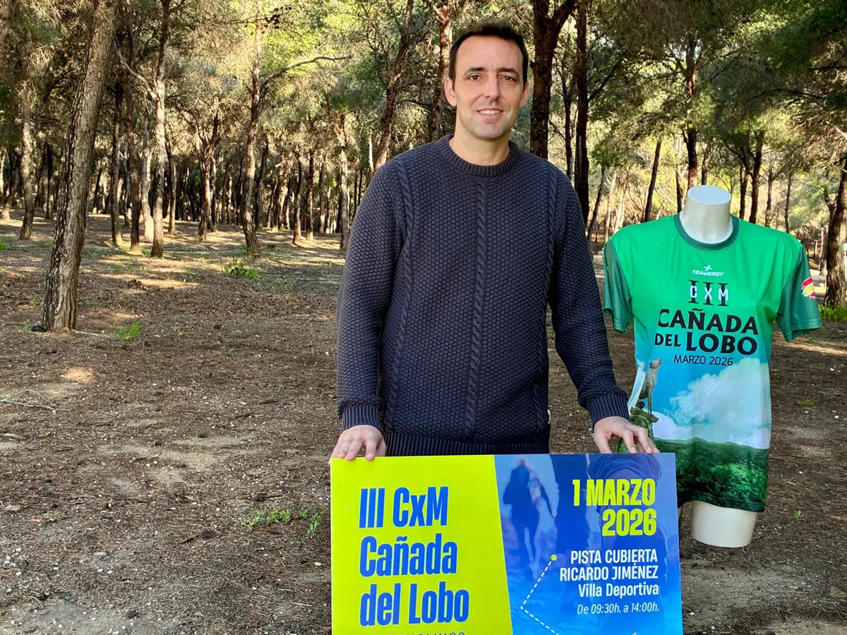 Concejal de Deportes de Torremolinos durante la presentación del III CxM Cañada del Lobo, junto al cartel de la prueba y la camiseta oficial en un entorno de pinar.