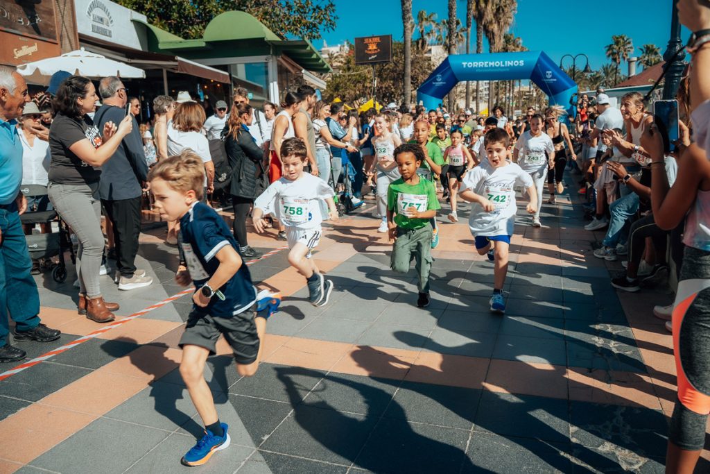 Niños y niñas participando en la prueba infantil de The Great Run La Carihuela en Torremolinos entre el aplauso del público