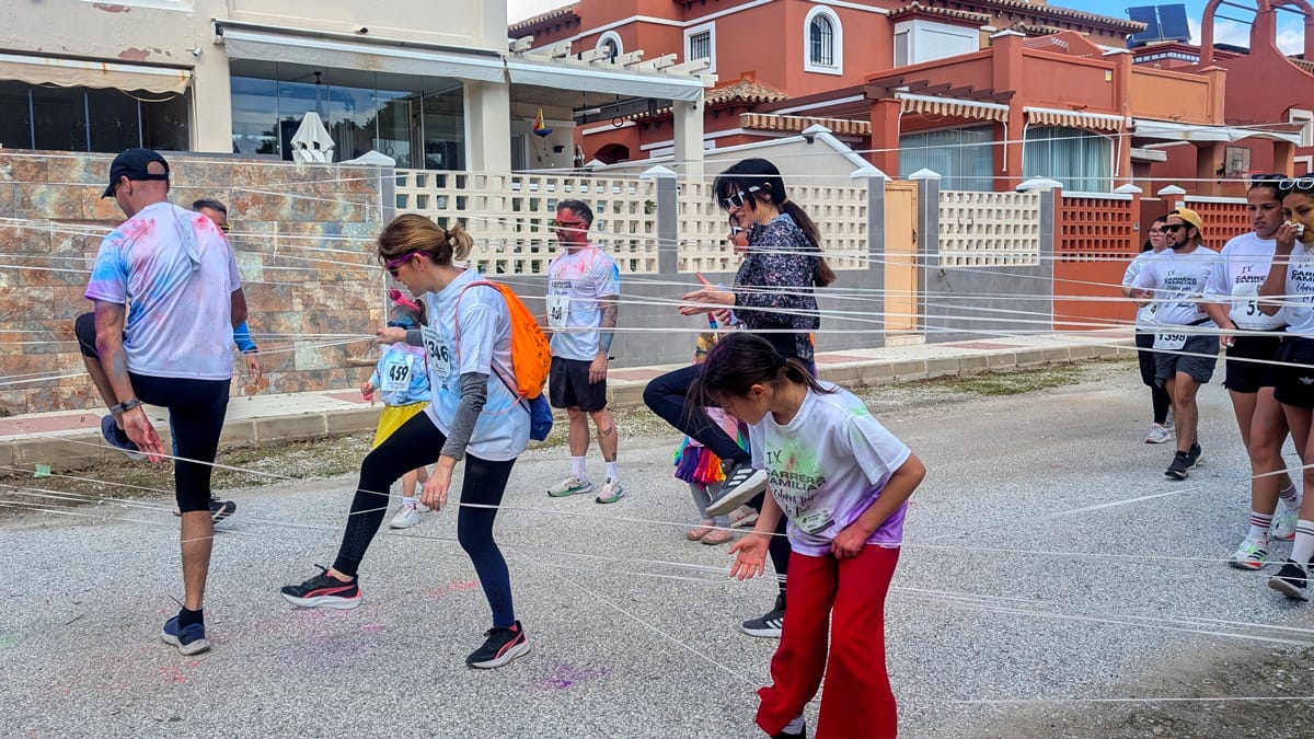Participantes superando el obstáculo de la tela de araña en la IX Carrera Familiar Colores para la Paz en Torremolinos